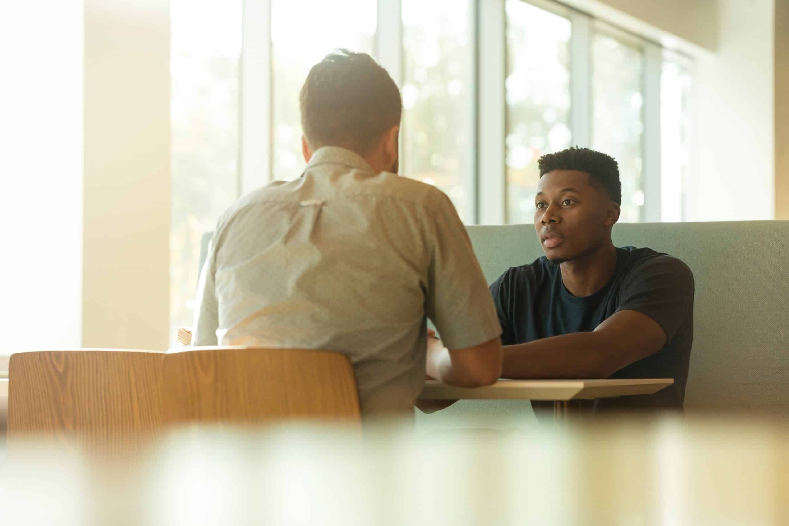 Two men discussing estate planning at a table.